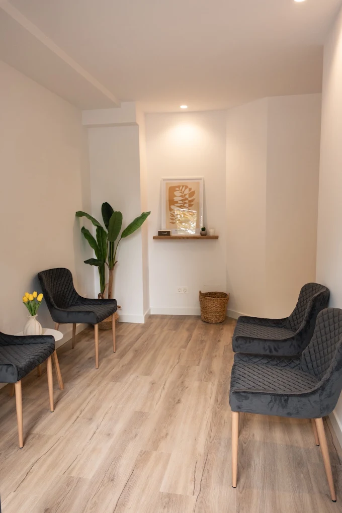Sala de espera con butacas, planta y luz cálida