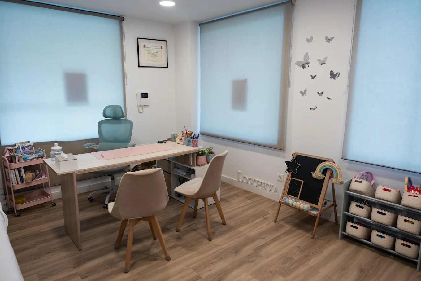 Sala de logopedia con mesa de trabajo, pizarra y material infantil