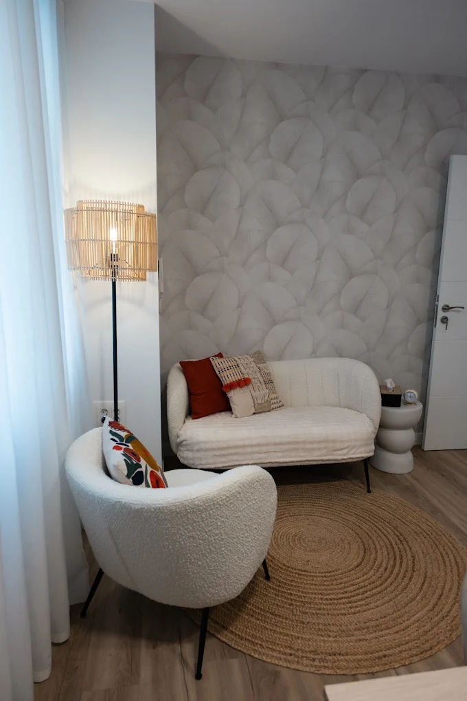 Rincón con sofá blanco, cojines y pared texturizada